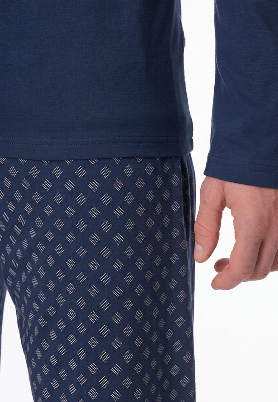 Close-up van de broek met streepjespatroon en de donkerblauwe pyjamatop.