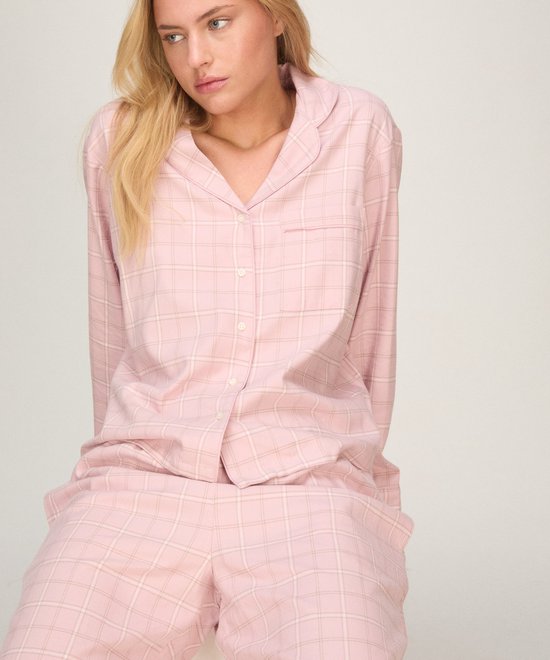 Model in roze geruite pyjamaset met lange knoopsluiting.