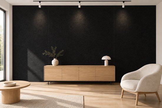 Zwarte viltwand in een woonkamer met houten meubels, een beige fauteuil en sfeerverlichting.
