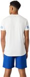 Man in wit sportshirt met blauwe tekst op de mouwen, en een blauwe short.