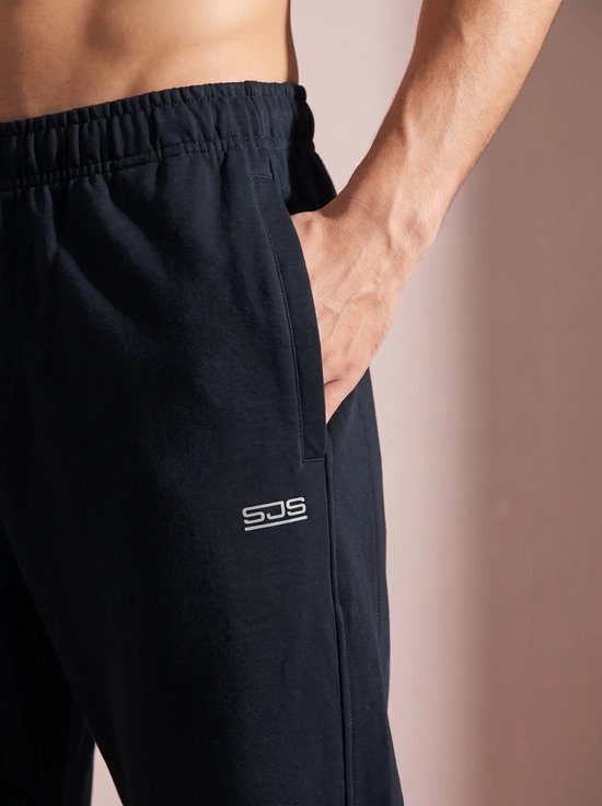 Détail d'un pantalon de sport bleu marine avec logo.