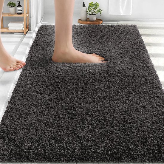 Zachte, donkergrijze badmat met antislip onderkant, met voeten erop.