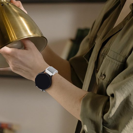 Persoon in olijfgroen overhemd draagt een smartwatch met een witte nylon horlogeband.