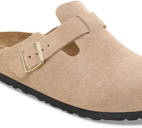 Close-up van de verstelbare gesp op een beige Birkenstock Boston suède klomp met zwarte zool.