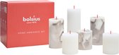 Bolsius Home Ambiance set met 7 stompkaarsen, wit en grijs marmerpatroon, met rode lontjes, naast de rode verpakking.
