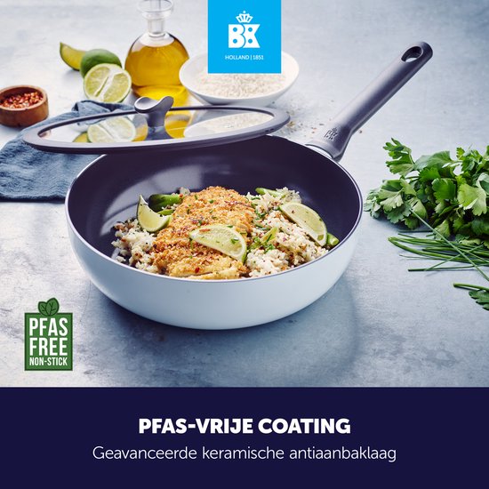 BK Enjoy wokpan met deksel, gevuld met rijst, kip en groenten, op een aanrecht met limoen, olie en kruiden. PFAS-vrij.