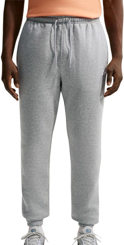 Grijze Nike joggingbroek voor heren met trekkoord en klein wit Nike logo op de linkerpijp.