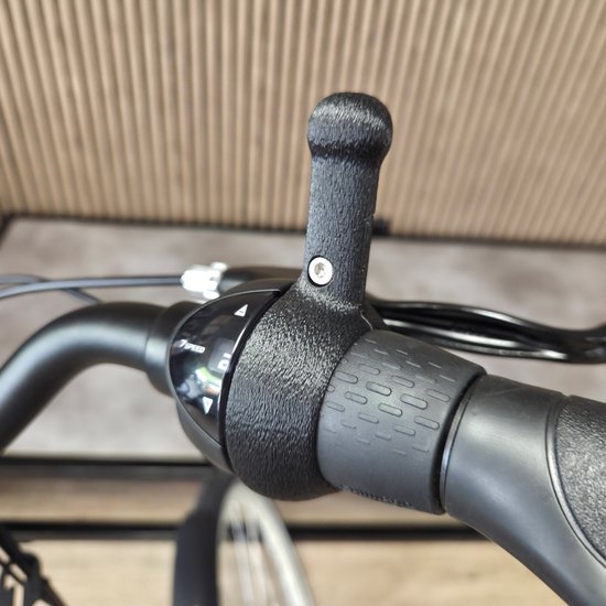 Zwarte 3D-geprinte schakelhulp gemonteerd op een Shimano Nexus 7-speed versnellingshendel van een fiets.