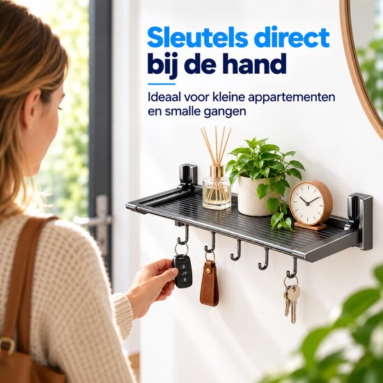 Vrouw hangt autosleutel aan grijze opvouwbare wandplank in een smalle hal.