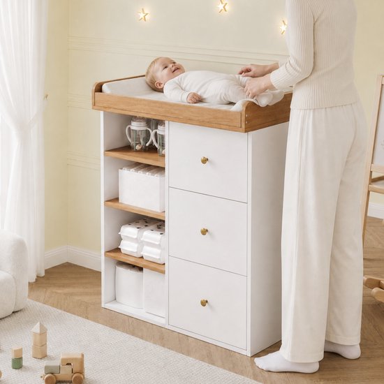 Vrouw die een baby verschoont op een wit-houten commode met drie lades en zijplanken in een kinderkamer.