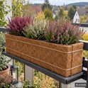 Langwerpige rechthoekige kokosvezel plantenbak met touwdetails, gevuld met roze en witte heide op een balkon.