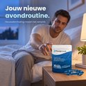 Homme au lit attrapant un emballage PurelyGoods. Bandelettes buccales bleues avec motif blanc sur la table de nuit. Produit anti-ronflement.