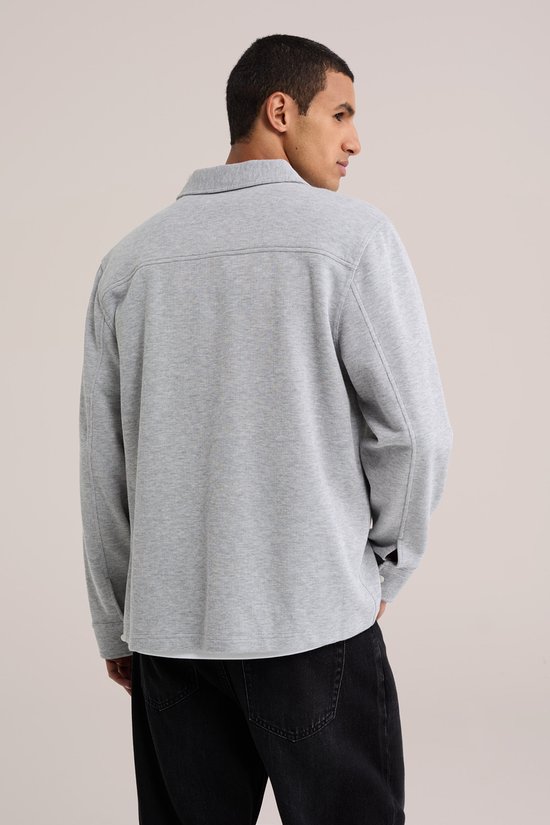 Achterkant van een grijs fijngebreid overshirt met kraag, gedragen door een model.