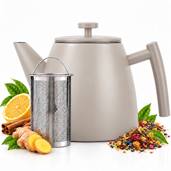 Beige theepot met RVS theefilter, omringd door citroen, gember en losse theeblaadjes.