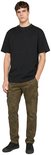 Man draagt een zwart T-shirt van Urban Classics met een camouflage cargobroek en zwarte sneakers.