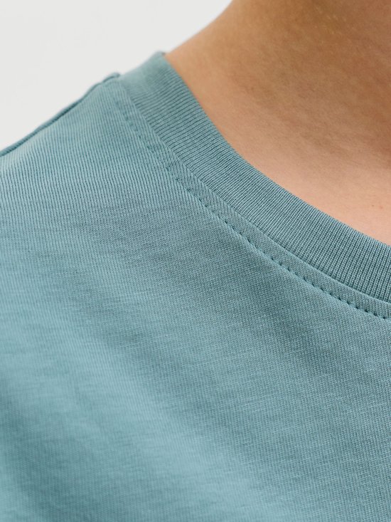Close-up van de geribbelde ronde halslijn van een blauw katoenen t-shirt.