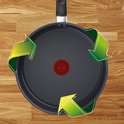 Zwarte Tefal koekenpan met Thermo-Signal stip in het midden, omringd door groene recycle-pijlen op houten ondergrond.