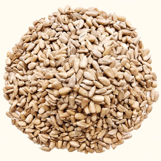 Hoop gepelde zonnebloempitten, beige van kleur en ovaal van vorm, compact gerangschikt op een lichte achtergrond.