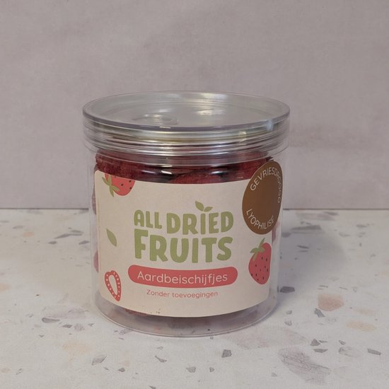 Transparante pot met label 'All Dried Fruits - Aardbeischijfjes' gevuld met gevriesdroogde aardbeien.
