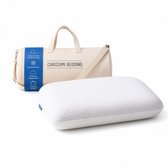 Wit traagschuim hoofdkussen van Carissimi Bedding met een beige reistas met tekst.