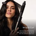 Model met lang, donker, golvend haar, wordt gefotografeerd terwijl de MAE Airstyler II krullen in haar haar maakt met het Coanda-effect.