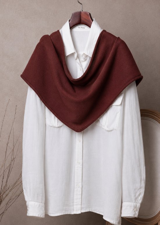 Bruine gebreide omslagdoek over een witte blouse met opgestreken kraag.