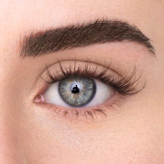 Close-up van een vrouwenoog met een volle, natuurlijke wimperlijn.