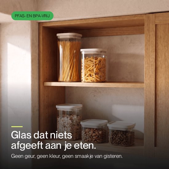 Bocaux de conservation transparents avec couvercles clairs remplis de spaghettis, penne, muesli, amandes et grains de café. Sans PFAS et sans BPA.