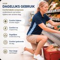 Een vrouw in een supermarkt met een beige kuitcompressiemouw, terwijl ze producten uit een schap pakt.