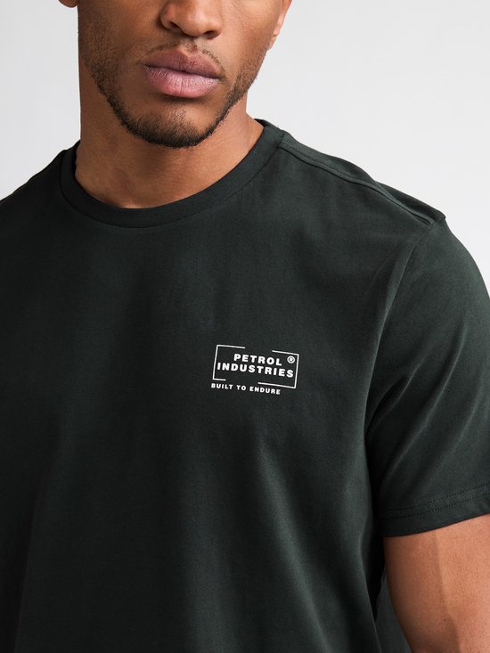 Close-up van donkergroen T-shirt met wit Petrol Industries 'Built to Endure' logo op linkerborst.