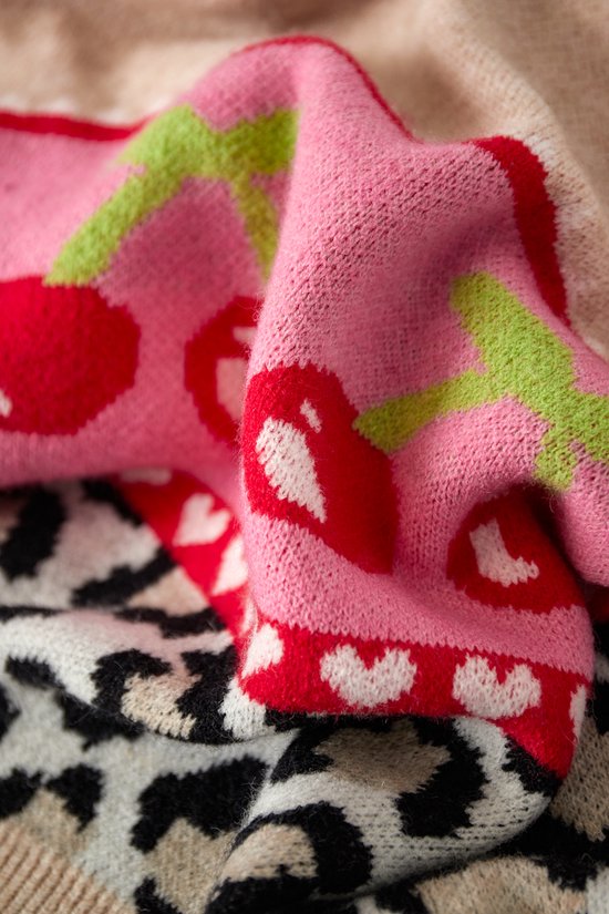 Roze gebreide stof met rode kersenprint en groene steeltjes. Leopardprint en hartjespatroon zichtbaar.