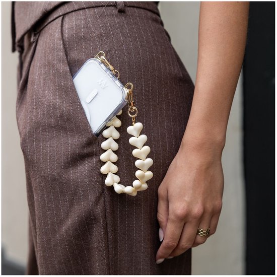 Lanyard adapter met een koord van beige hartjes, bevestigd aan een telefoonhoesje in een broekzak.