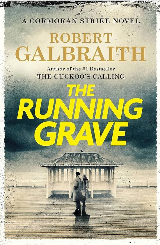 Boekomslag van "The Running Grave", een Cormoran Strike-roman van Robert Galbraith, met op de voorgrond twee figuren bij een strandpaviljoen.