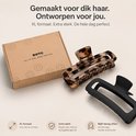 Doos met BOTC logo, een luipaardprint haarklem en een zwarte XL haarklem, gemaakt voor dik haar.