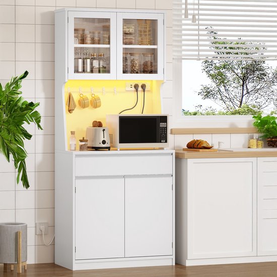 Witte keukenkast in een keuken met raam, inclusief magnetron en broodrooster.