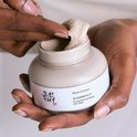 Jar met Beauty of Joseon Ground Rice and Honey Glow Mask, met textuur van rijst en honing, in handen.