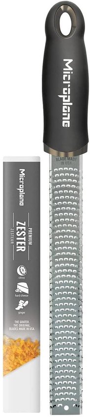 Râpe Microplane noire avec emballage "Zester" indiquant "agrumes", "fromage à pâte dure", "gingembre".