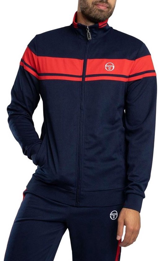 Donkerblauw trainingsvest met rode borststreep, rits en wit Sergio Tacchini-logo op de borst gedragen door een model.