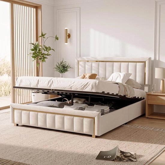 Un lit beige rembourré avec rangement ouvert, rempli d'oreillers et de vêtements.