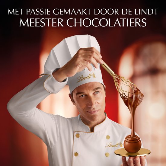 Meester chocolatier met Lindt logo met garde, die chocolade in een Lindt bal doet.