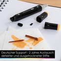 Zwarte twin marker met gele dop, deels gedemonteerd, met inktvlekken op papieren zakdoekjes.