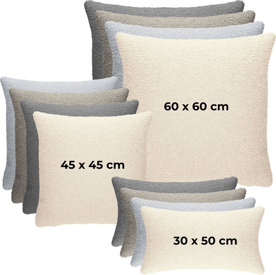 Een stapel teddy kussens in beige, grijs en lichtgrijs in de maten 30x50, 45x45 en 60x60 cm.