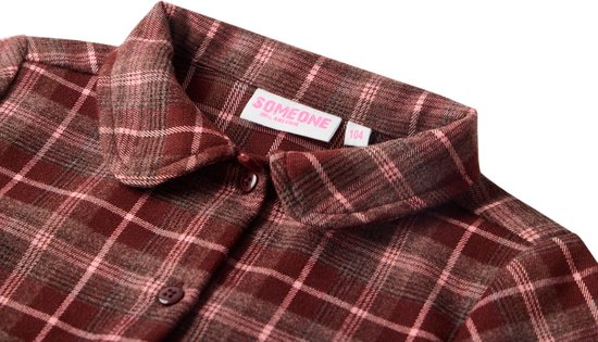 Sluiting van de bordeauxrode jurk met ruiten, met knopen en een kraag. Het label 'SOMEONE' is zichtbaar.