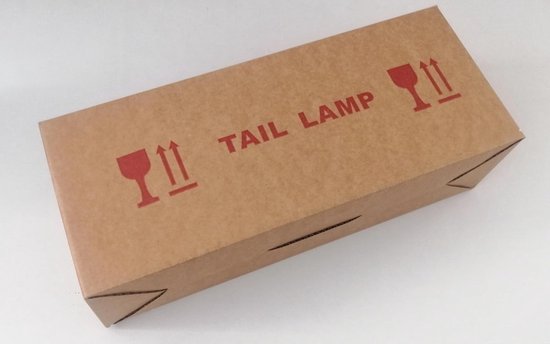Bruine kartonnen doos met de tekst 'TAIL LAMP' en icoontjes voor breekbare goederen.