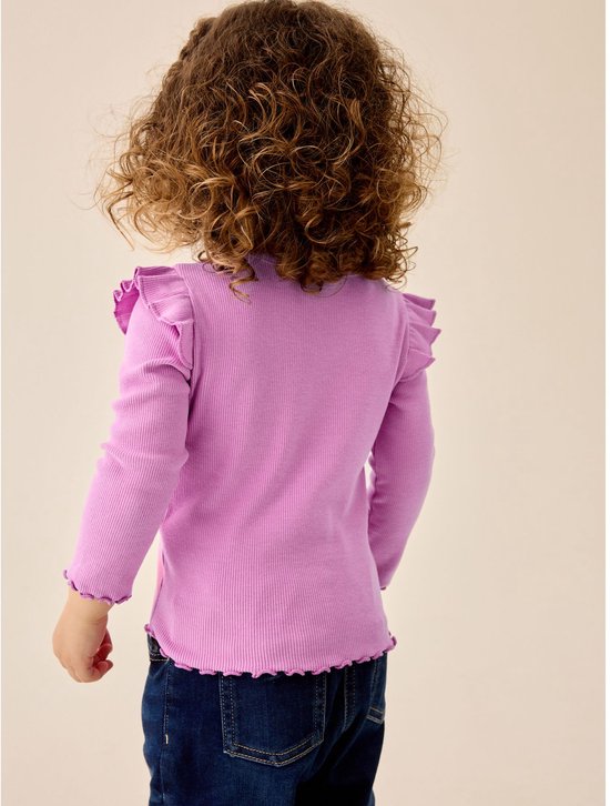 Meisje met krullend haar, de achterkant van een paars shirt met ruches op de schouders en gegolfde zoom.