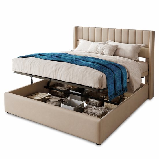 Beige gestoffeerd tweepersoonsbed met open hydraulische opbergruimte gevuld met diverse manden. Een blauwe plaid ligt op het opgemaakte bed.
