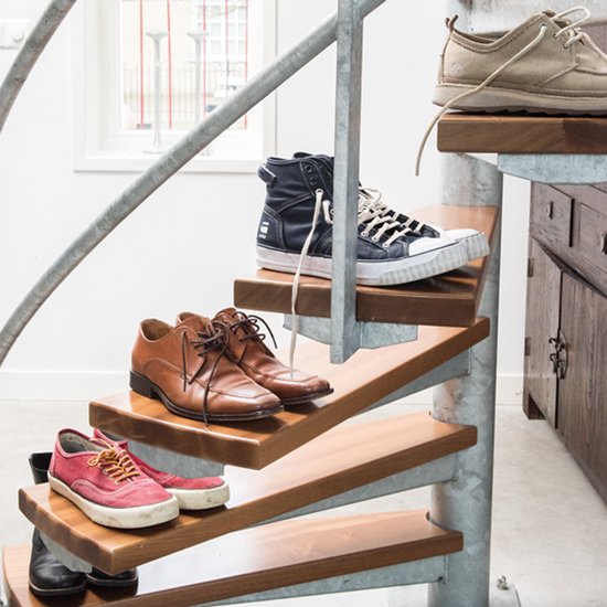 Diverse herenschoenen op een houten spiltrap.