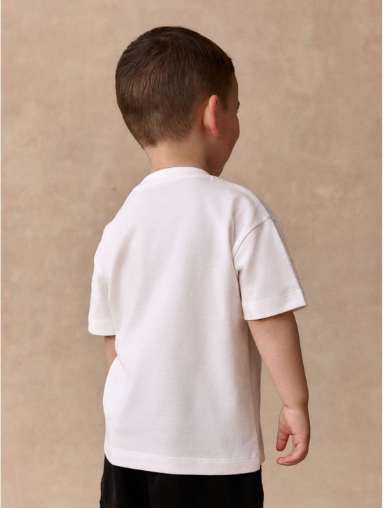 Achterkant van een eenvoudig wit T-shirt gedragen door een jongen.