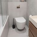 Moderne badkamer met een witte hangtoilet, zwarte toiletborstel in houder en houten wastafelmeubel.