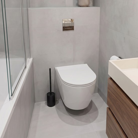 Moderne badkamer met een witte hangtoilet, zwarte toiletborstel in houder en houten wastafelmeubel.